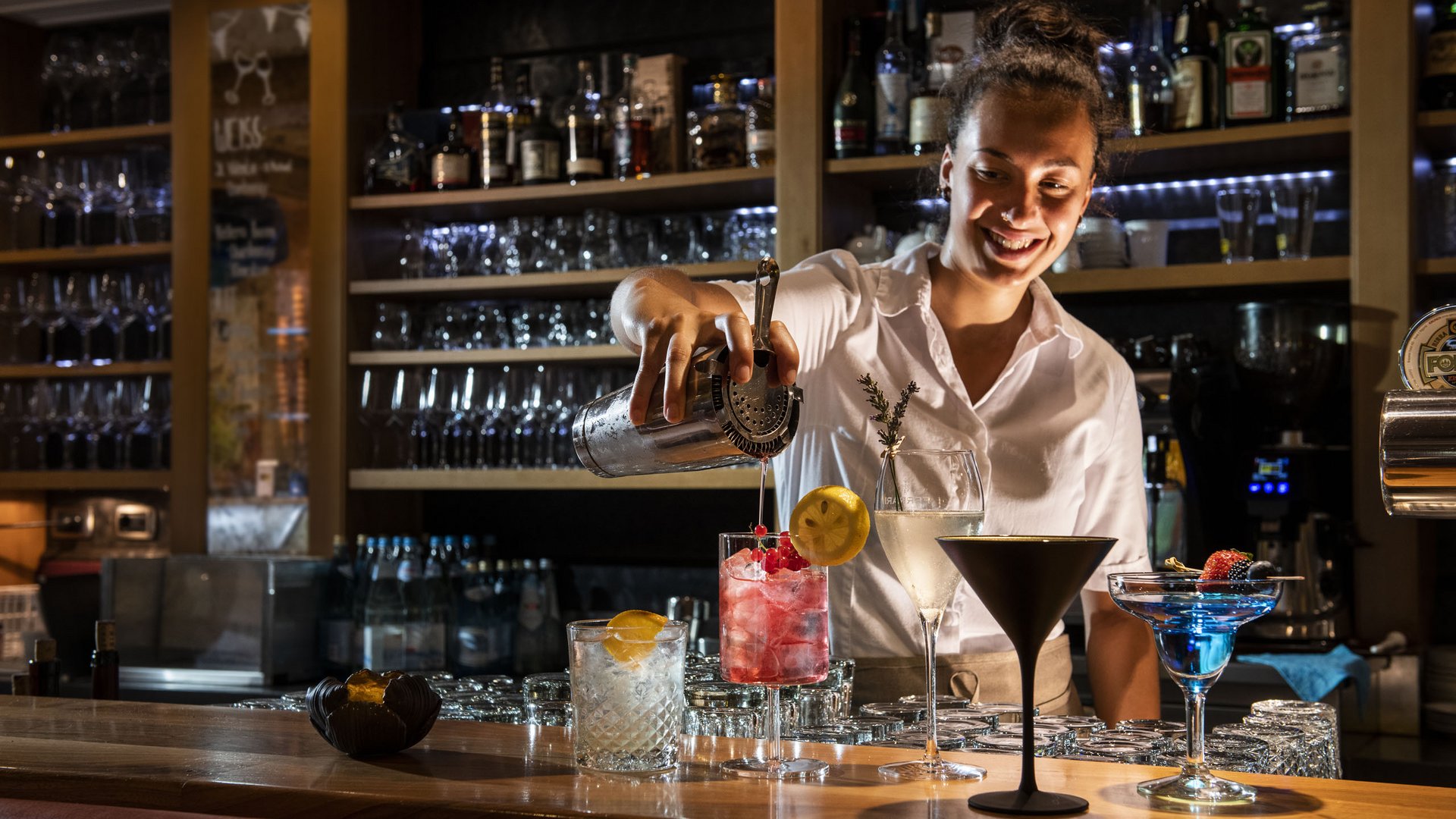 Hotel benessere in Alto Adige: posizioni Barista versa bevanda in un bicchiere in un bar