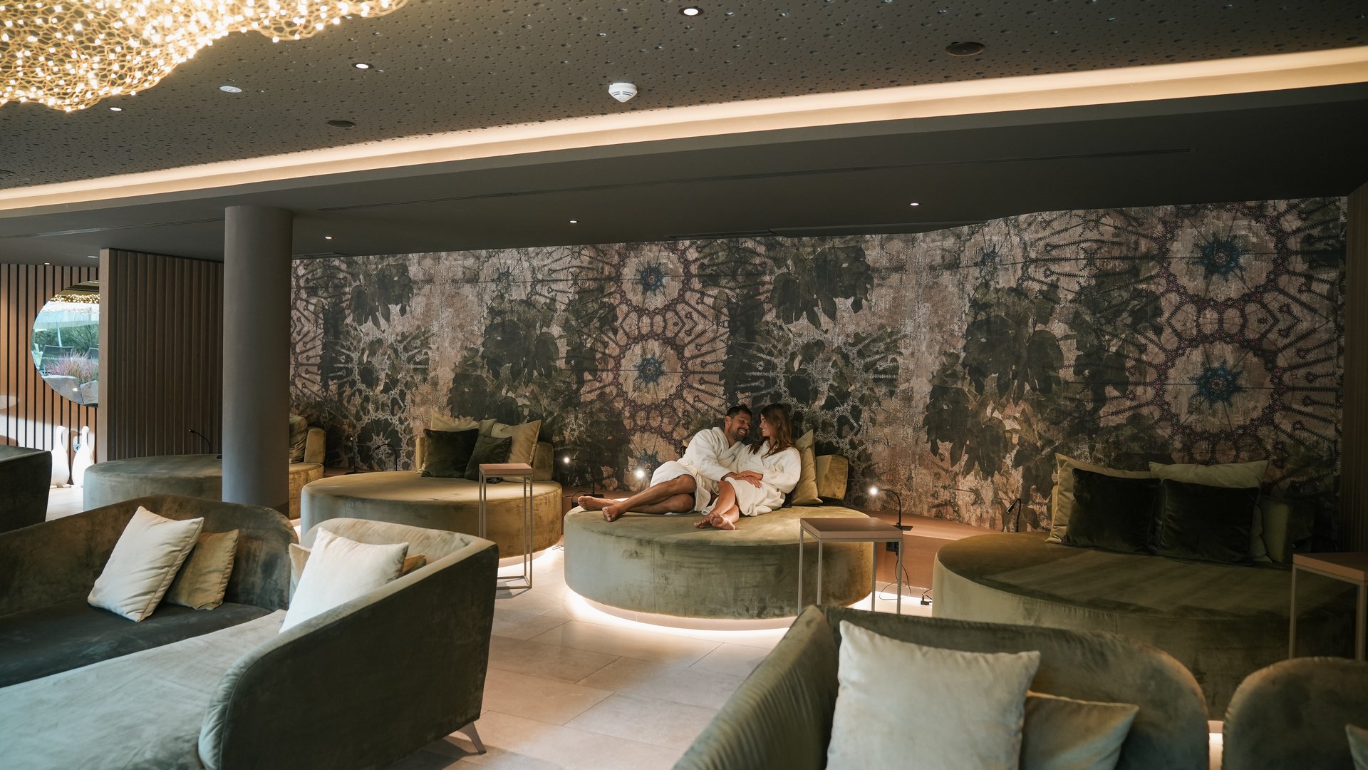 Hotels nahe dem Kalterer See 4-Sterne-Superior Paar entspannt sich in luxuriösem Spa-Wartebereich mit runden Sitzen und düsterer Einrichtung