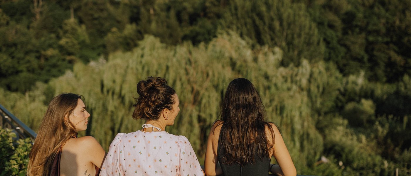 Hotel near Eppan an der Weinstraße: Gartenhotel Moser Three women stand on a balcony looking at a lush green forest
