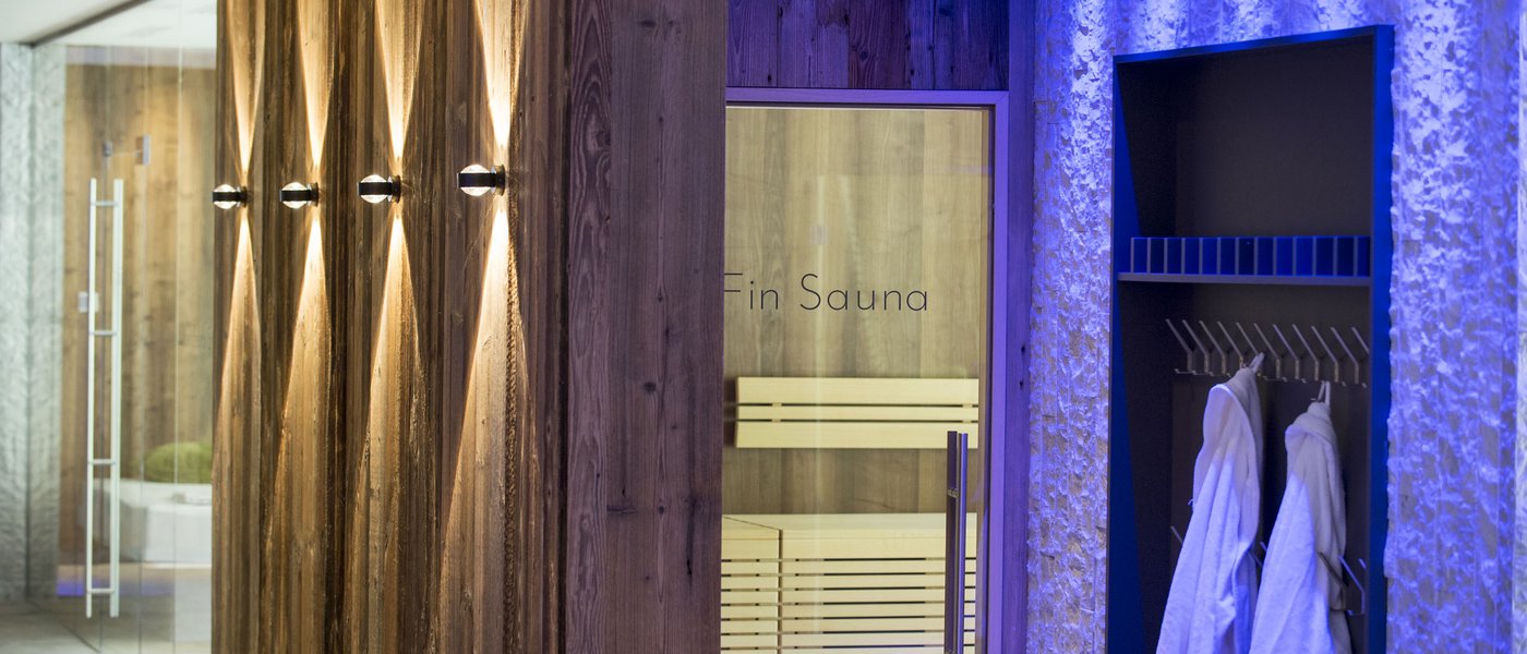 Wellness hotel with whirlpool and sauna world Modern sauna area with wood walls and bathrobes hanging on hooks