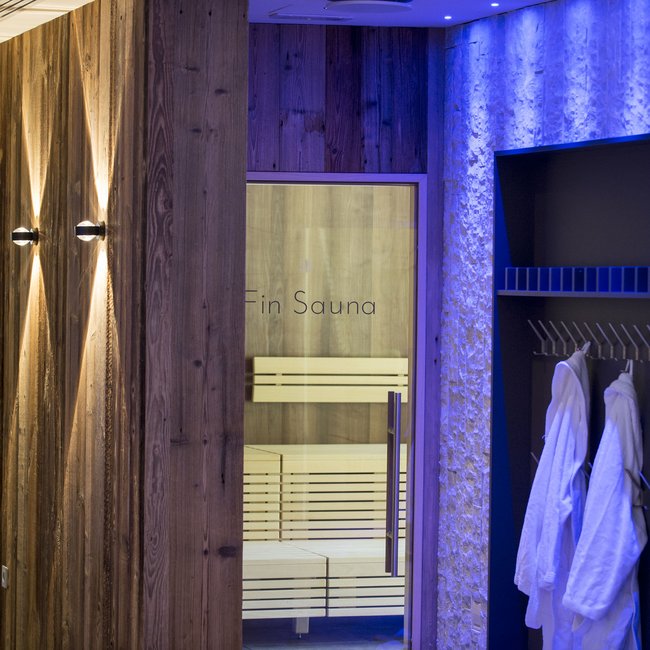 Hotel on Lago di Monticolo/Montiggler See: Gartenhotel Moser Modern sauna area with wood walls and bathrobes hanging on hooks