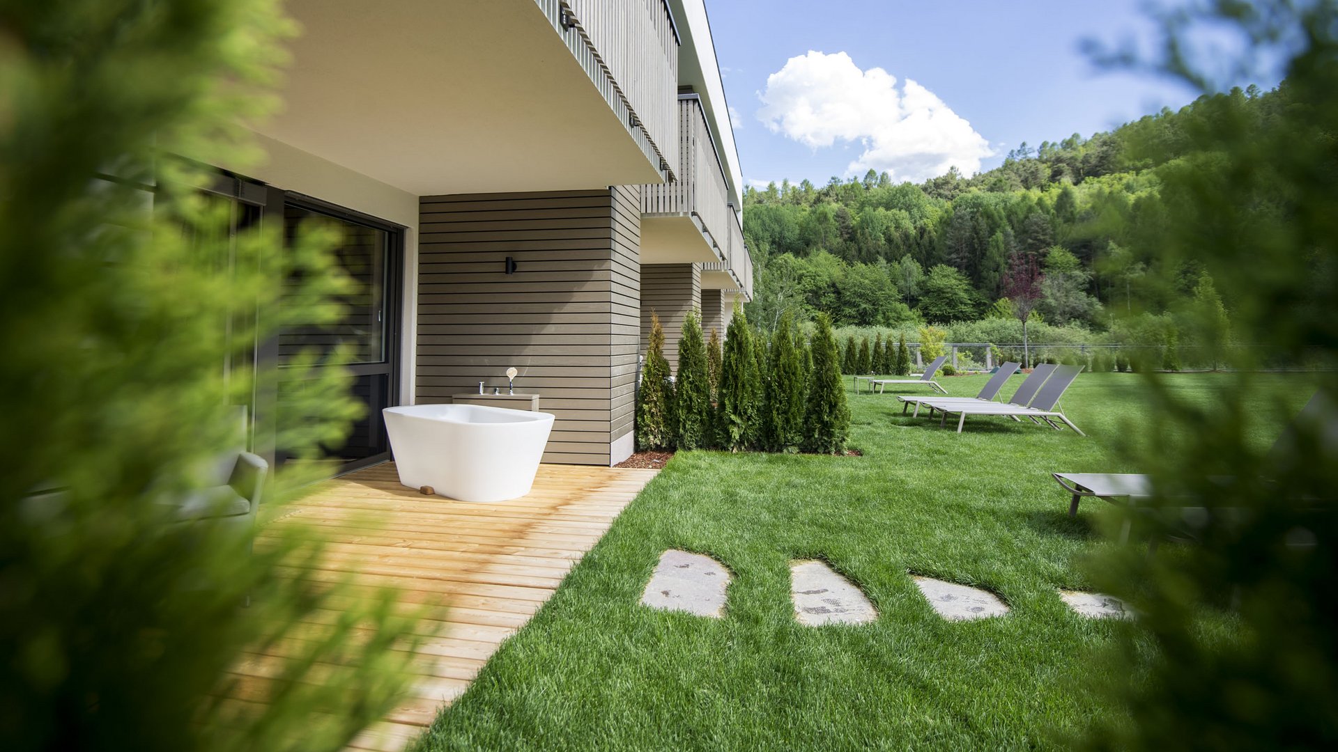 Hotel near Eppan an der Weinstraße: Gartenhotel Moser Modern outdoor area with bathtub, lounge chairs, and green lawn