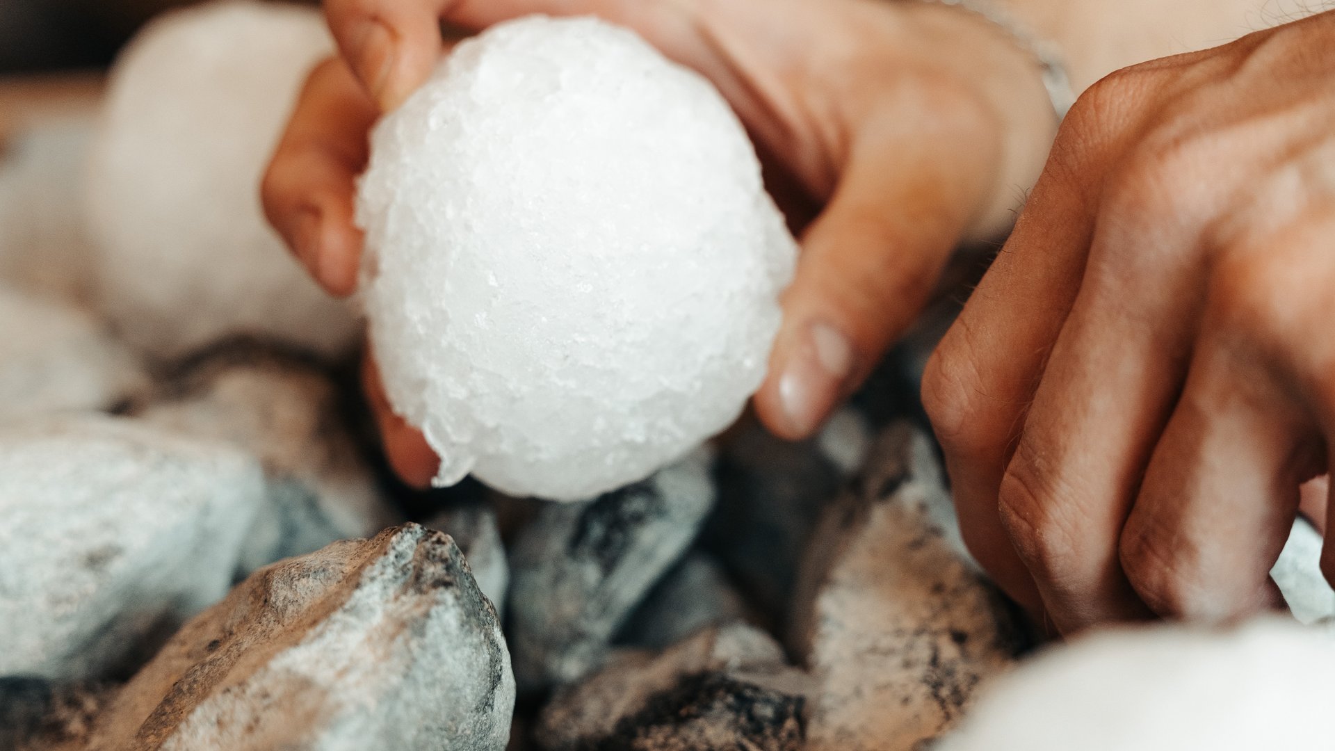 Wellness hotel with whirlpool and sauna world Hands holding white sauna infusion stone on hot stones