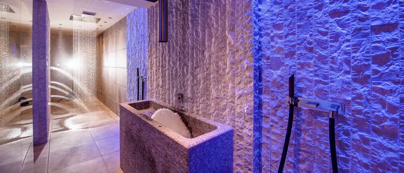 Wellness hotel with whirlpool and sauna world Modern wellness shower area with illuminated stone and water features