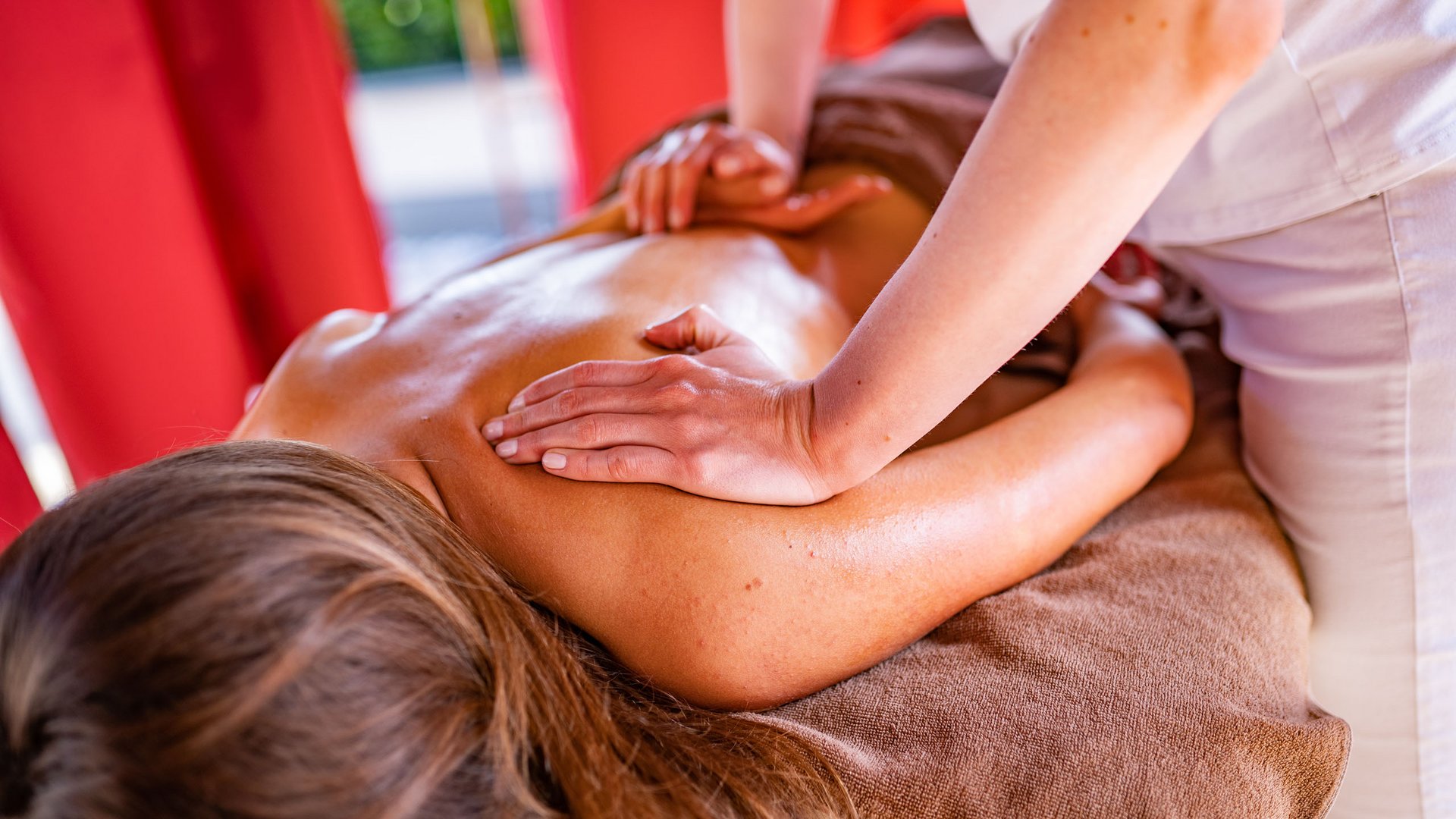 Hotel benessere in Alto Adige: posizioni Donna che riceve un massaggio alla schiena in un ambiente rilassante